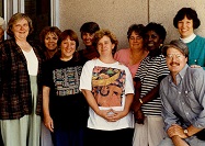 Nine women and one man stand for a photograph in front of a hospital entrance.