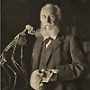 Portrait of Ernst Haeckel (1834–1919) holding a skull, standing next to a monkey skeleton. Image B013669 in the Images from the History of Medicine (IHM) collection.