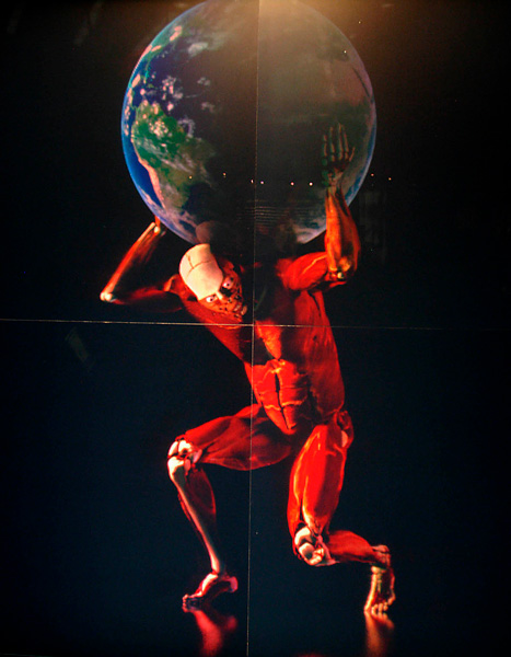 human with exposed muscle holding the Earth