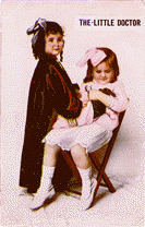 A color photograph post card titled The Little Doctor, featuring a girl wearing a red robe and glasses is examinging a bear being held by a girl seated in a chair.