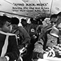 African American men and women seated on a plane.