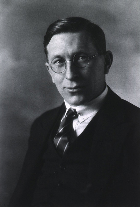 Black-and-white photo of F. G. Banting wearing round glasses, a tie, vest, and jacket.