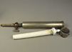 White ceramic filter tube with nipple on one end and metal pipe-like case for the ceramic filter.