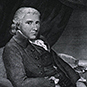 Benjamin Bell wearing a jacket and sitting in a chair looking at the viewer.