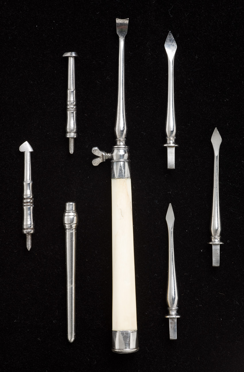 Dental scaler set of long silver instruments with pointed edges.