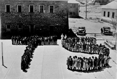 A group of Native Americans standing in front of a building forming two letters, 'T' stands for Trachoma, 'S,' for Sulfanilamide. Two female nurses stand behind the letters at the Trachoma School Fort Defiance Arizona, 1941. Courtesy the National Archives and Records Administration. Sulfanilimide was used to treat trachoma.