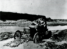 A Public Health Service physician sitting in his car which is stuck in the mud. Image A020775 from Images from the History of Medicine (IHM).