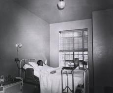 A sick Native American woman lies in hospital bed at the Indian Sanitorium, Albuquerque, New Mexico.