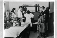 Nurse Mary B Russell (right) and Assistants Mae Howard and Roland Begay (left) take a chest x-ray of a patient Trachoma School Fort Defiance Arizona, 1941. Courtesy the National Archives and Records Administration.