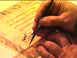 Mohamed Zakariya's left hand holding a plastic ruler down with his left hand while putting on black line on the paper with his right hand.