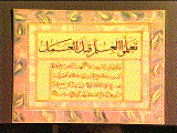 The completed work featuring marbled paper bordering the Arabic script on the inside. The script is from the Imam Malik and says: 'earn knowledge before you do anything'.