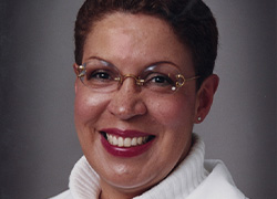 A woman’s portrait wearing a white shirt and jacket.