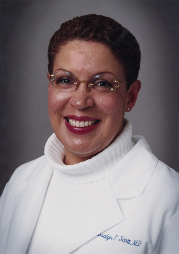 A woman’s portrait wearing a white shirt and jacket.