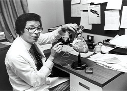 Man seated at a desk with a model of the heart on the desk.