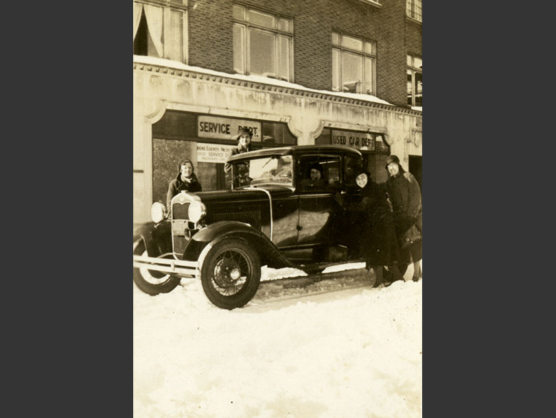 4 White female nurses around a Ford Model A Coupe at East 200th Street with snow in the Bronx.