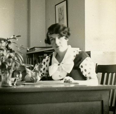 A White woman sitting behind a desk in an office.