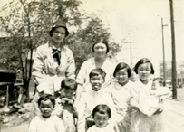 White, female nurse with a Chinese-American family comprised of a mother and seven children.
