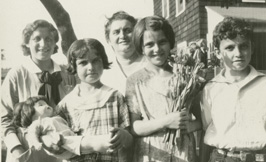 A family group with children posed outside a home.