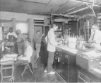 Six men at work in an early laboratory of the Bureau of Chemistry.