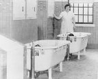 A nurse at St. Elizabeths Hospital for the mentally ill in Washington, D.C., stands monitoring two patients in two continuously flowing baths.