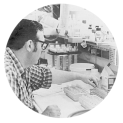 The head and shoulders photograph of a researcher in a laboratory placing a test tube in test tube container.