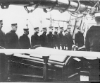 Twelve Public Health Service officers stand on the deck of the Coast Guard Cutter Bear.