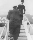 A foreign quarantine inspector of the Public Health Service climbs the debarking stairs of a newly arrived plane at Kennedy International Airport in New York City. A flight attendent stands at the top of the stairs.