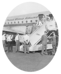 Passengers from Cairo, Egypt, debarking down the embarking stairs from their airplane at Kennedy International Airport in New York City with inspection officers Weeks and Evans in front. On the ground, seven more inspection officers wait.