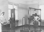 A woman stands in the middle of an X-ray machine while a nurse stands behind a protective shield in a U.S. quarantine office in Berlin, Germany.