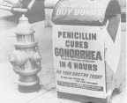 A poster attached to a curbside mailbox offering advice to World War II servicemen that penicillin cures gonorrhea in four hours.