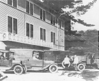 Ambulances and other vehicles parked by the San Francisco Public Health Service Hospital, circa 1920. Several people are either standing by the vehicles or are seated inside them.