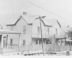 Exterior view of a house that converted into a small temporary trachoma hospital in Jackson, Kentucky. An American flag is posted off the second balcony.