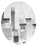 An oval photograph of  various vials and containers of drugs and vaccines.