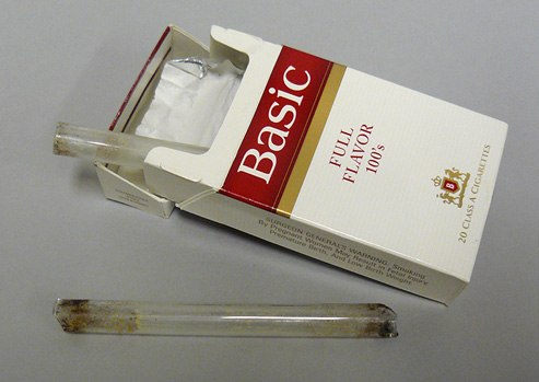 Photograph of a cigarette box with two glass pipes for smoking crack.
