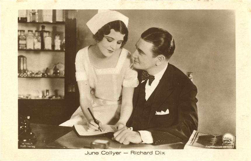 Two White film stars. Female nurse sits on the male doctors' leg to write in a notebook.