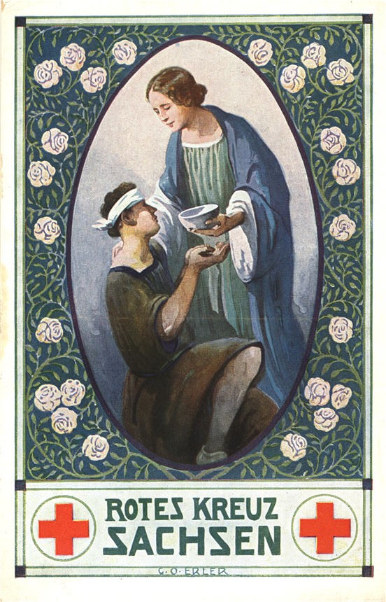 A White female nurse in green and blue gown, bringing a bowl to the mouth of a wounded White male.