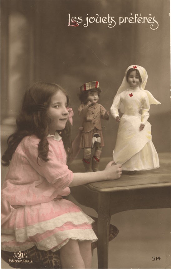 A white girl playing with a nurse doll and a Scottish soldier doll.