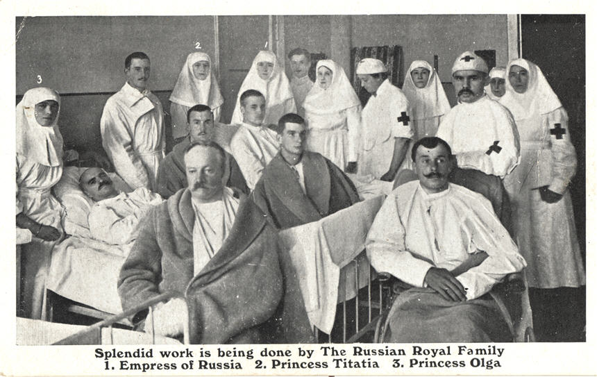Several White women nurses stand amongst wounded White soldiers in a hospital ward.