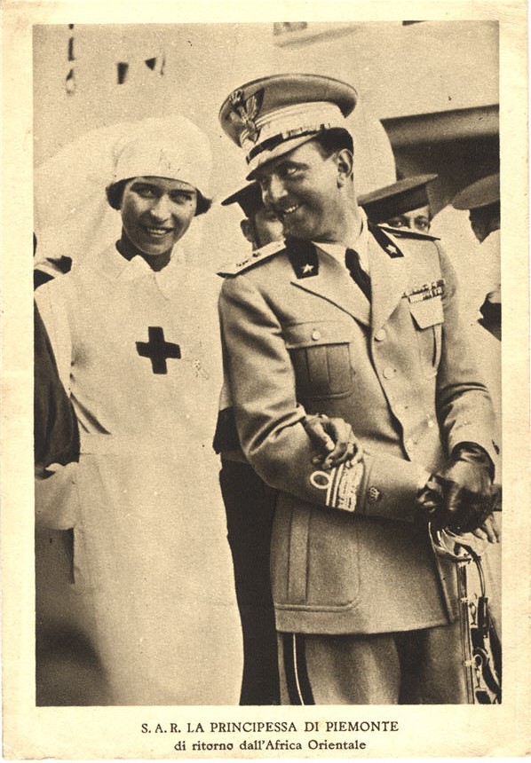 A White female nurse (Princess Maria Josè) arm in arm with a White male soldier.