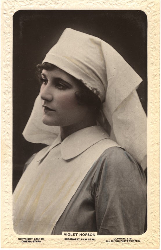 A White woman (Violet Hopson) dressed as a nurse, looking to the left.