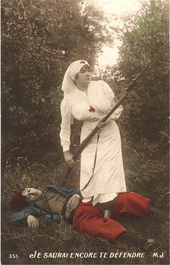 A White female nurse in white with rifle, standing over an unconscious wounded White male soldier.