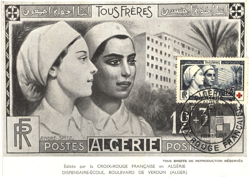 A White female nurse and a Berber-Arab female nurse, stand in front of a hospital.