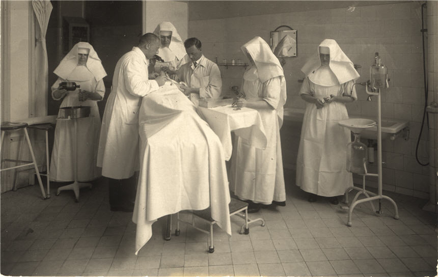 Two White male doctors and four White female nurses operating on a patient in a hospital.