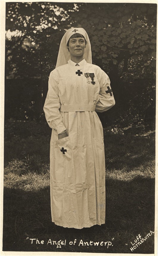 White female nurse in white wearing war medals and looking slightly to the right.