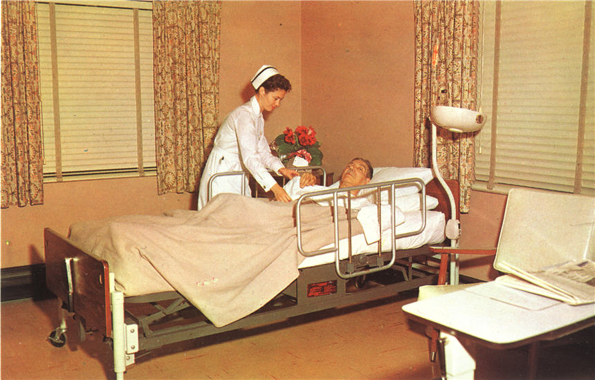 A White female nurse in white tends to an elderly White male patient in bed.