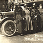 Six White female nurses standing in front of a car with a Red Cross symbol on a 