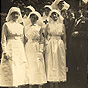 Ten White female nurses and one White man in a suit, standing and looking at the viewer.
