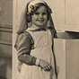 White female child-actress (Shirley Temple) dressed as a nurse and looking at the viewer.