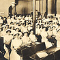 A nursing school classroom filled with a large group of White women, and two African American women.