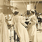 Groups of White female nurses, some wearing goggles, administer treatment to patients.